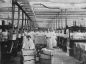 Schiedam industry 4. Labourers transporting candles from the molding chamber at the candle factory Apollo on  Voorhavenkade, ca. 1910. Author: A. Dettmeijer.