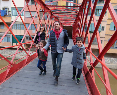 Family strolling through a bridge in Girona
